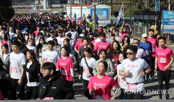 지난해 3월 24일 부산 해운대구 수영만 요트경기장에서 열린 핑크런 부산대회에서 참가자들이 분홍색 옷을 입고  달리고 있다. 유방암 예방을 위한 핑크리본 캠페인의 일환이다. (연합뉴스)
