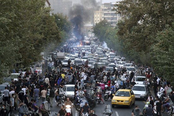 21일 테헤란 시내에서 히잡 반대 시위대가 도로를 막은 채 시위를 벌이고 있다. 사진은 현지인이 촬영한 것으로 AP통신이 입수해 공개했다. (AP/연합뉴스)