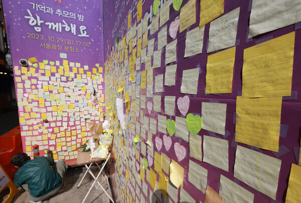 이태원 참사 1주기를 2주 앞둔 15일 서울 용산 이태원의 참사 골목에 설치된 '10.29 이태원 참사 기억의 길'에서 한 시민이 추모메세지를 붙이고 있다. (연합뉴스)