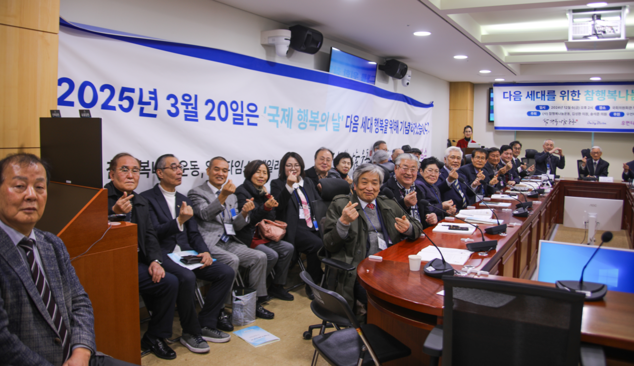 12일 국회의원 회관 제5간담회의실에서 열린 포럼에서 참가자들이 2025년 '3월 20일 국제행복의 날을 기념하겠다'는 플래카드 앞에서 손 하트를 날리고 있다. (사진=참행복나눔운동)