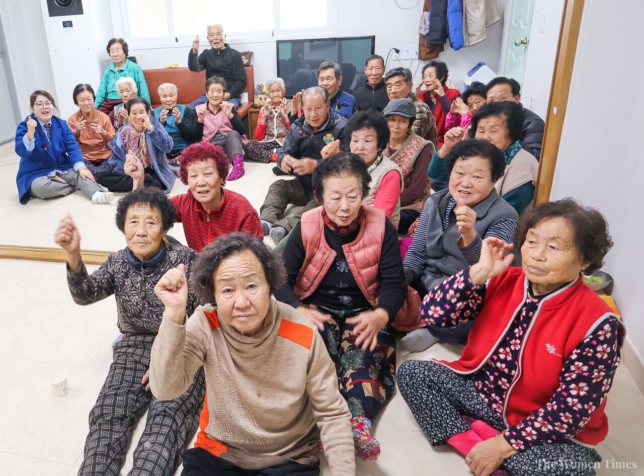 공주시 사곡면 계실리 경로당에서 25일 어르신들이 성탄 떡국 점심을 마치고 한 자리에 모였다. 뒤편 왼쪽 끝 파란 옷이 함은혜 대표